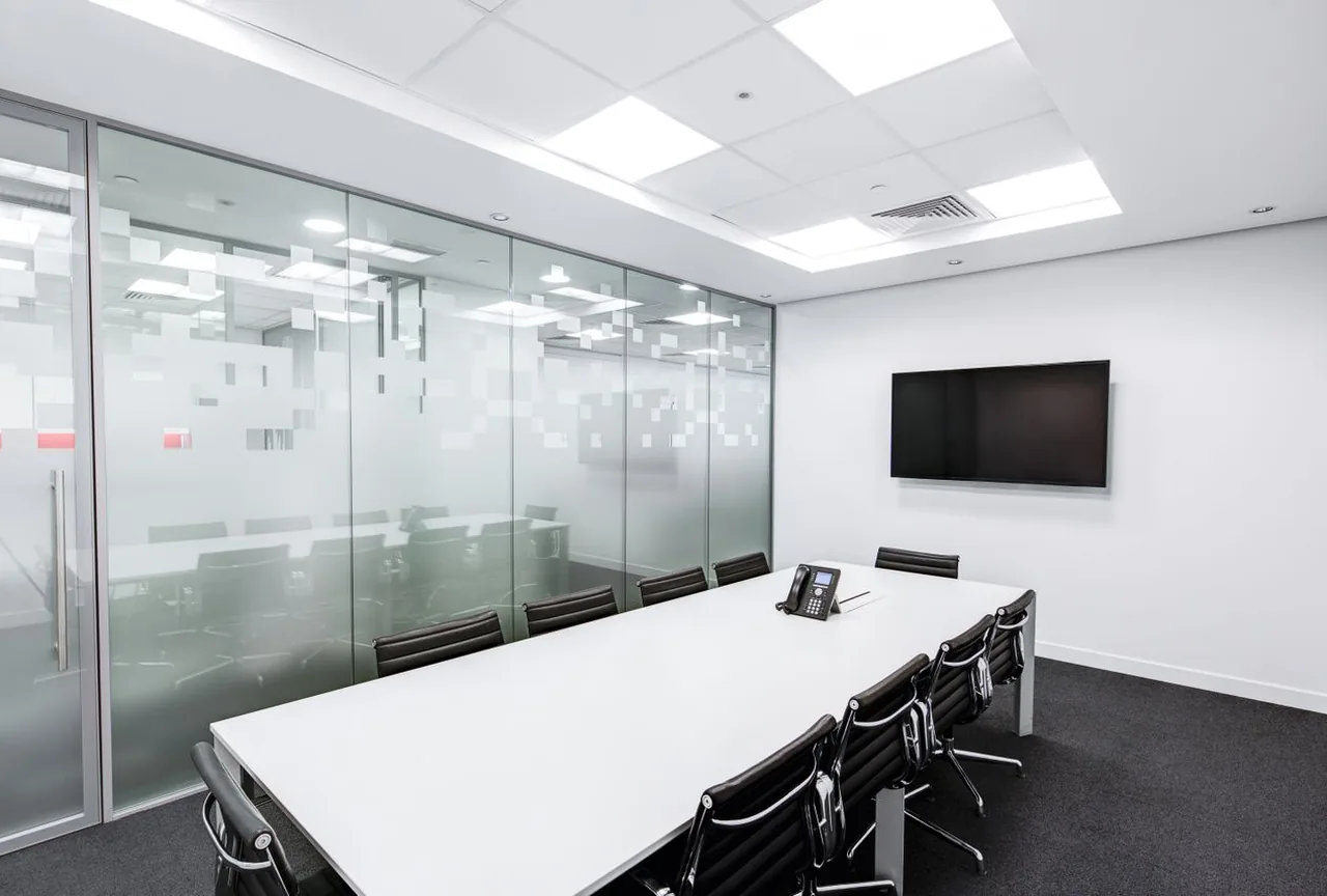 Empty glass-walled underwriting conference room in cool daylight
